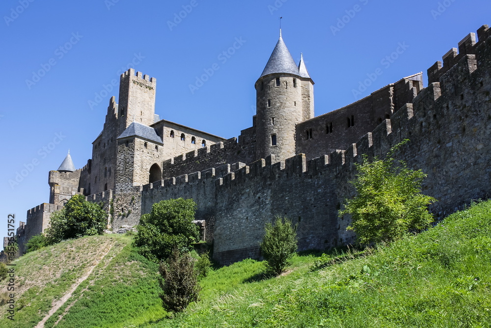 France, Carcassonne- AUGUST 28, 2014. Powerful fortifications and bastions of Carcassonne Castle. Beautiful conical blue roofs of towers.