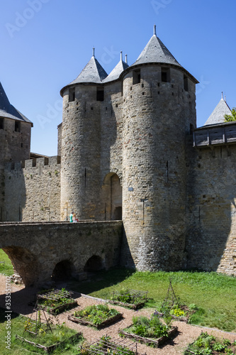 France, Carcassonne— AUGUST 28, 2014. Powerful fortifications and bastions of Carcassonne Castle. Beautiful conical blue roofs of towers. Bridge and entrance to the central fortress