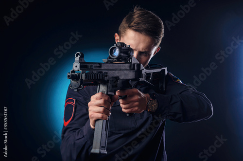 a guy in a police uniform with a short barreled automatic rifle with a telescopic sight takes aim