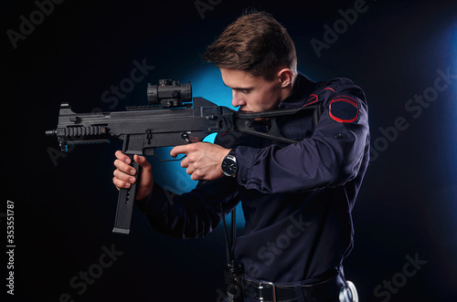 a guy in a police uniform with a short barreled automatic rifle with a telescopic sight takes aim