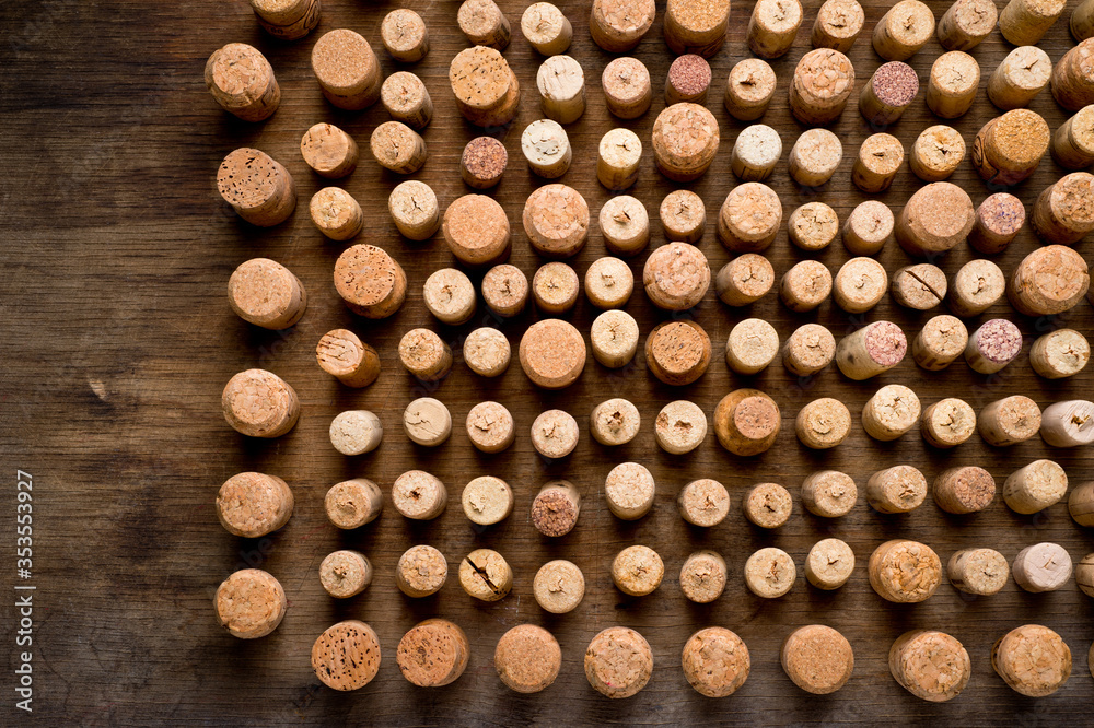 Wine corks of different sizes, standing upright on an old wooden surface. Background for liquor. Wine corks of different sizes, standing upright on an old wooden surface. Background for liquor.