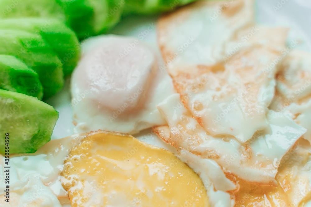 yellow and white fried eggs with green cucumber slices yellow and white fried eggs with green cucumber slices