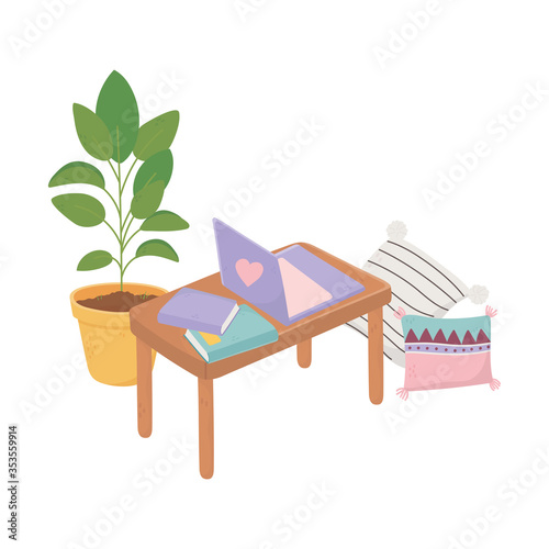 sweet home table with laptop books, cushions and potted plant