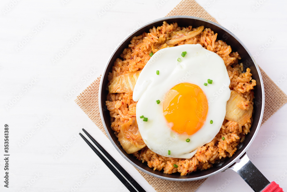 Kimchi fried rice with fried egg in cooking pand and chopsticks, Korean food Kimchi fried rice with fried egg in cooking pand and chopsticks, Korean food
