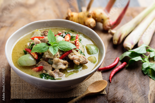 Thai food, Green curry with pork (Kang Keaw Wan) in bowl and ingredients on wooden background