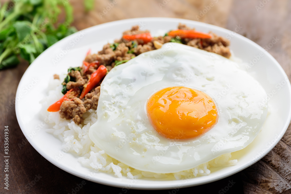 Thai food, stir-fried holy basil with minced pork and fried egg (Pad Kaprao Moo Kai Dao) on plate Thai food, stir-fried holy basil with minced pork and fried egg (Pad Kaprao Moo Kai Dao) on plate