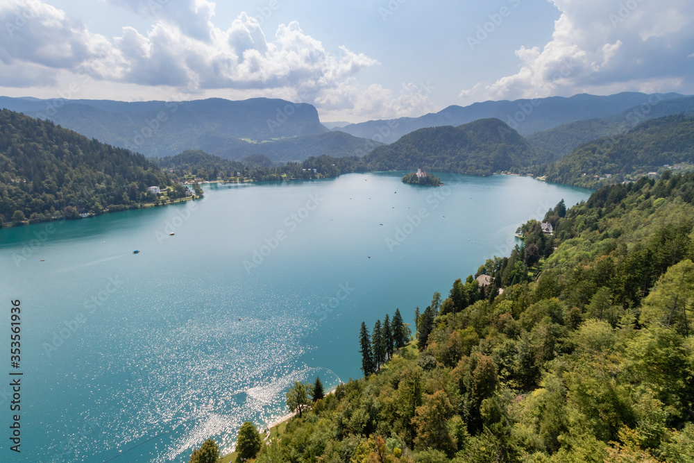 Lake Bled with a small island in the middle and surrounded by mountains covered with green forest. Slovenia, Bled.