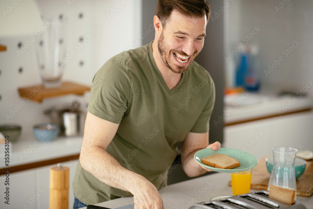 Handsome man eating breakfast at home. Happy man enjoying in morning. Handsome man eating breakfast at home. Happy man enjoying in morning.