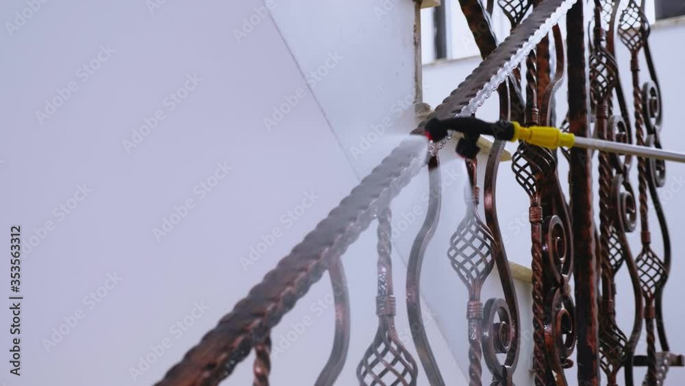 Close up of virologist spreading chemical on balustrade against covid-19 spread.