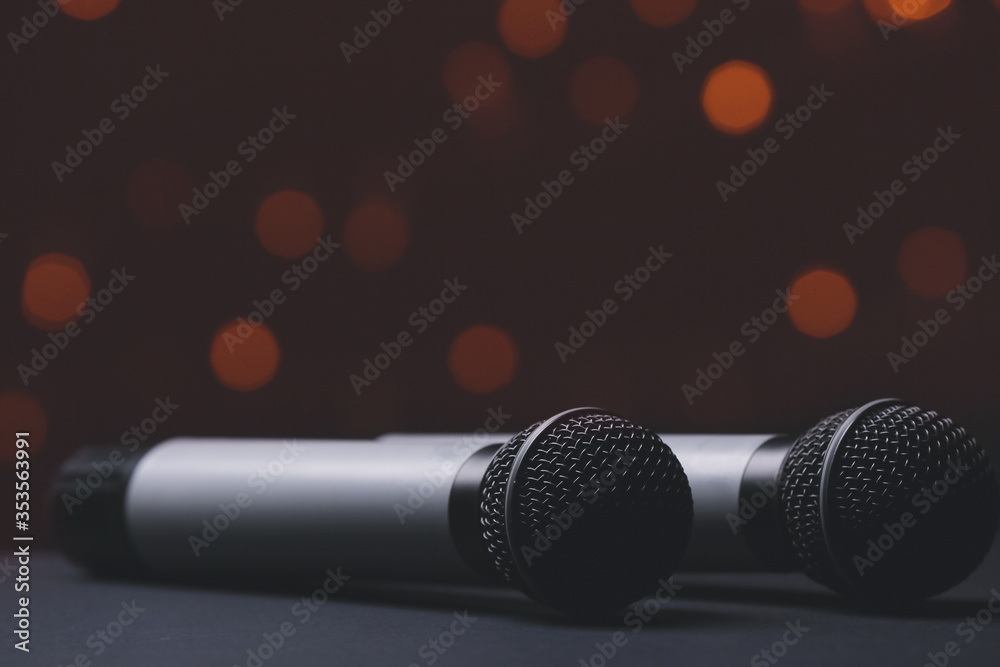 Obraz premium Two Professional Microphones with Warm Bokeh Lights