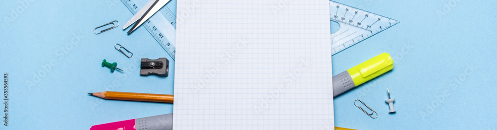 School supplies at the notebook on a blue background. The view from the top. Mock up school banner. Back to school! School supplies at the notebook on a blue background. The view from the top. Mock up school banner. Back to school!