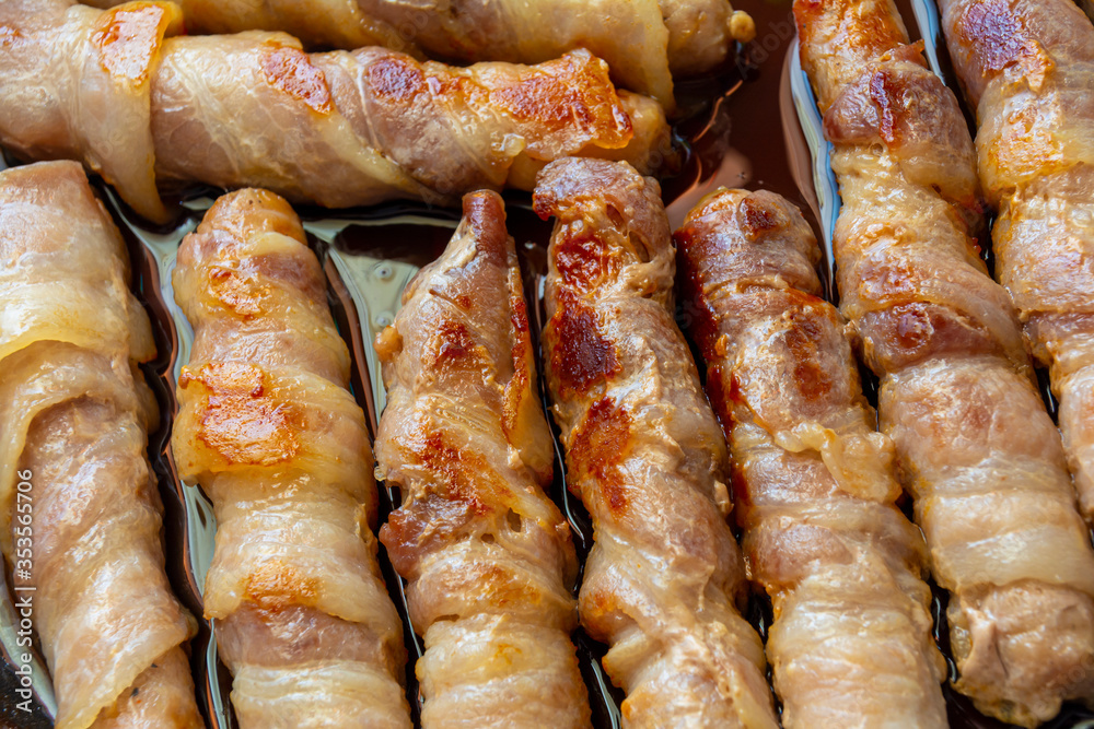 Fried sausages in bacon. bacon roll closeup. Abstract background with bacon.