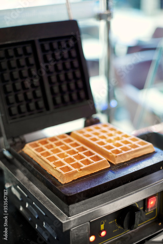 Fototapeta Naklejka Na Ścianę i Meble -  Freshly baked waffles in a professional waffle machine