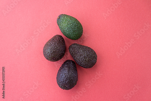 Avocado in different degrees of ripeness on a red background. Flat lay style. Close up. Place for text