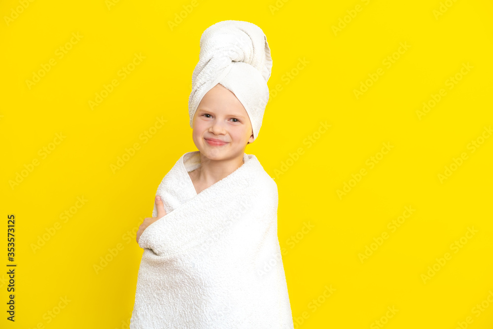 Portrait of cute little caucasian girl wrapped in white towel with bath towel on head over yellow studio background. Spa procedure, bath textile. Portrait of cute little caucasian girl wrapped in white towel with bath towel on head over yellow studio background. Spa procedure, bath textile.