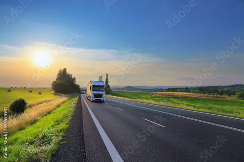 White truck transport on the road  at sunset and cargo