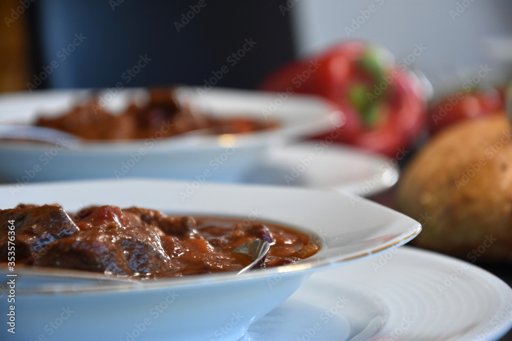 Beef Stew mexican style - with kidneybeans Paprika and tomatoes on a white plate served on a dark table - close up Beef Stew mexican style - with kidneybeans Paprika and tomatoes on a white plate served on a dark table - close up