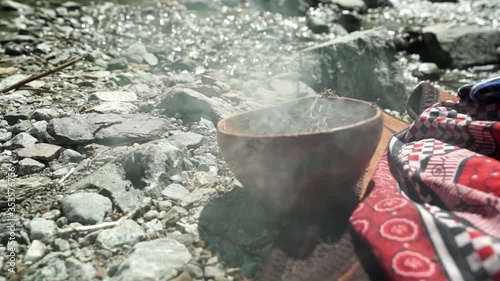 Smoke pouring out of a red clay burning bowl, offerings for ancestors, slow motion photo