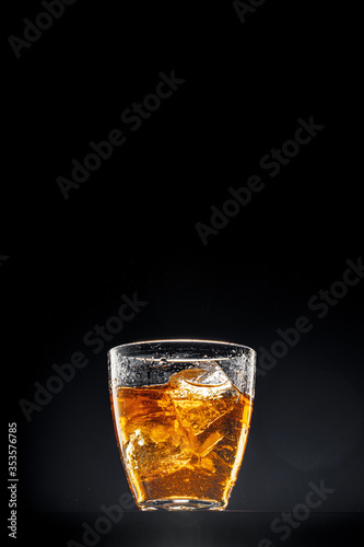 Glass of whisky on black background, copy space