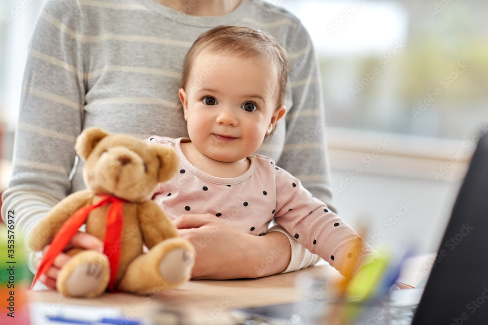remote job, multi-tasking and family concept - close up of happy baby with mother working at home office remote job, multi-tasking and family concept - close up of happy baby with mother working at home office