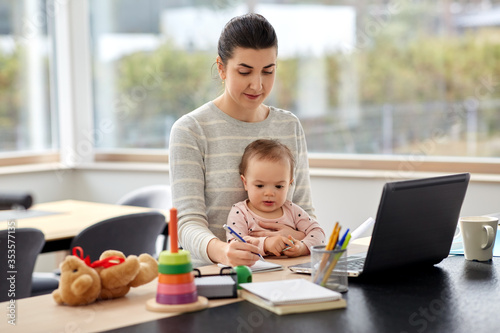 remote job, multi-tasking and family concept - mother with baby working at home office