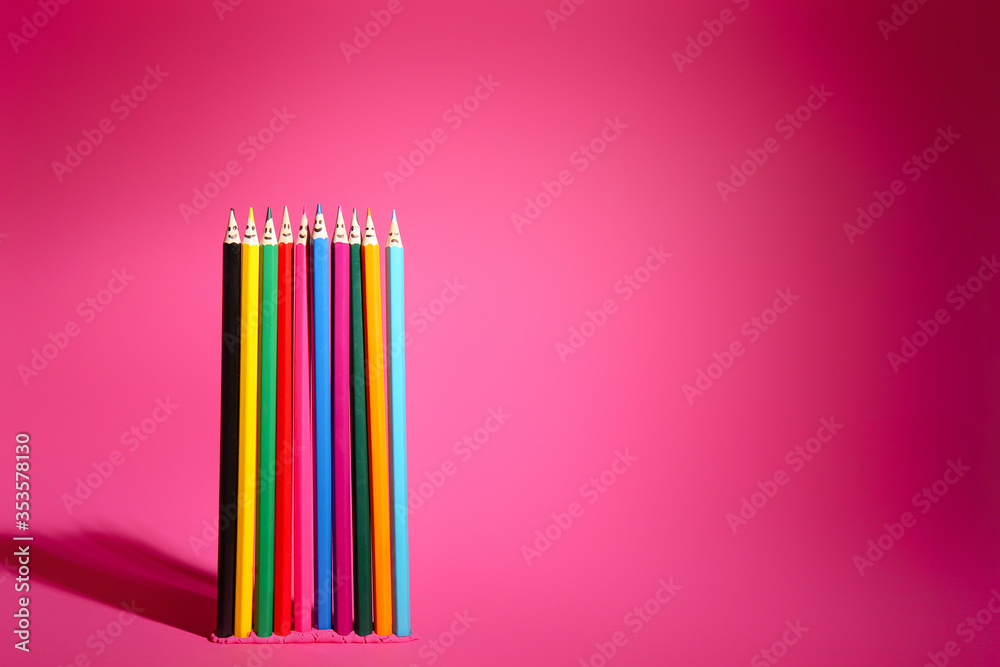 Colorful pencils with drawn faces on pink background. Unity concept - obrazy, fototapety, plakaty 