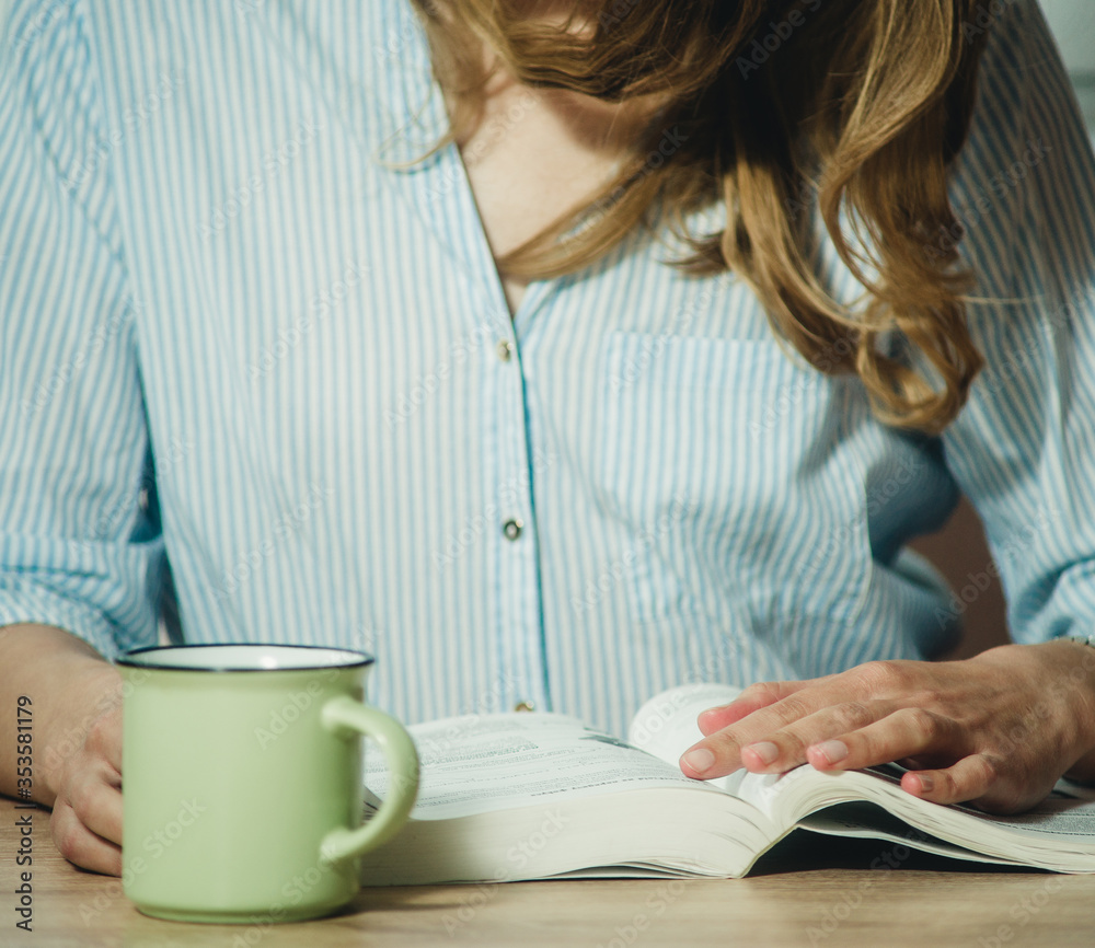 Obraz premium girl reading a book at the table close-up