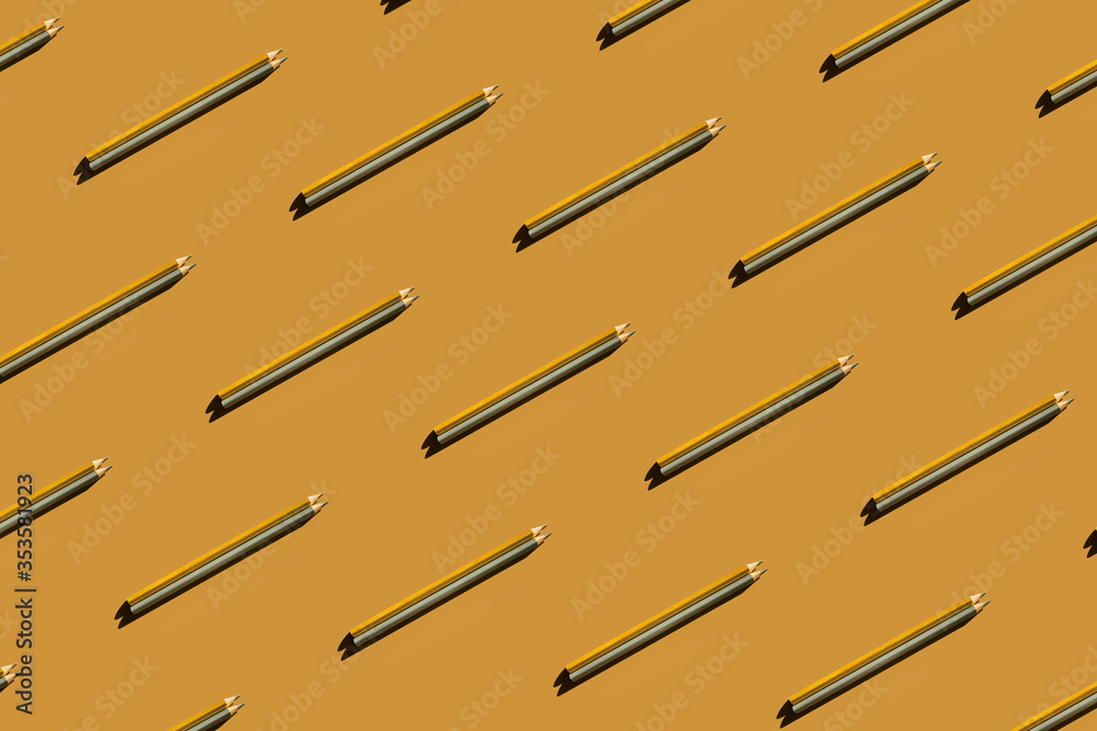 Pattern of trendy gold and silver pencils on gold background. Back to school, education and learning concept. Minimal modern concept. Pattern of trendy gold and silver pencils on gold background. Back to school, education and learning concept. Minimal modern concept.