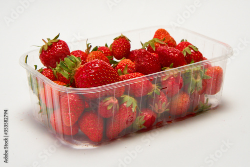 Tray of ripe red strawberries on a white background.