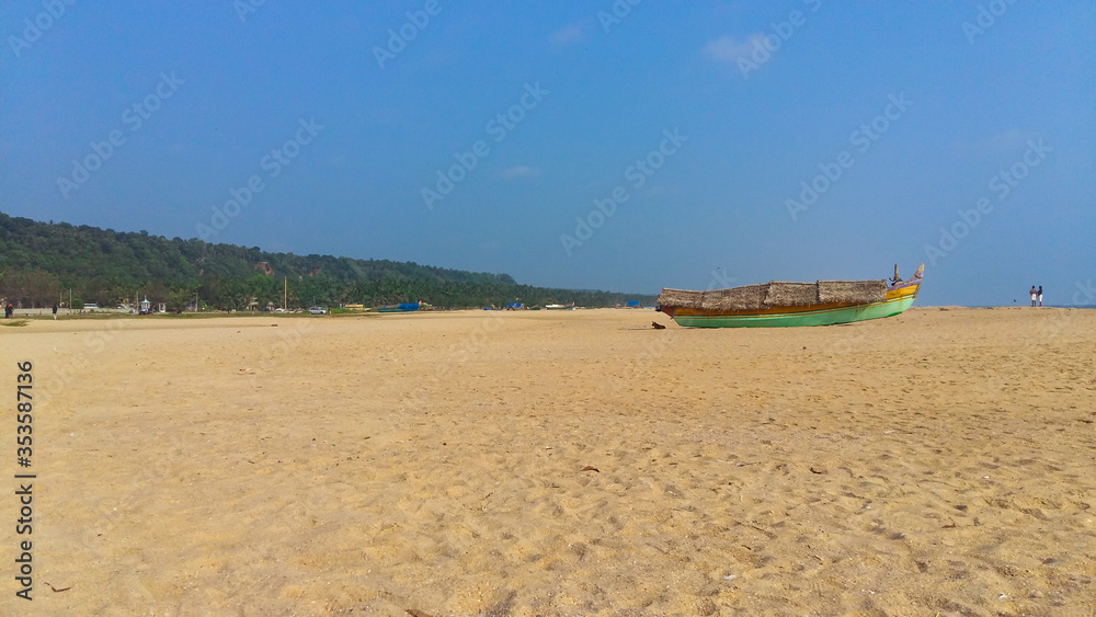 Landscape image of sandy Azhimala Beach in Trivandrum, Kerala, India with a parked fishing Boat on sand. Landscape image of sandy Azhimala Beach in Trivandrum, Kerala, India with a parked fishing Boat on sand.