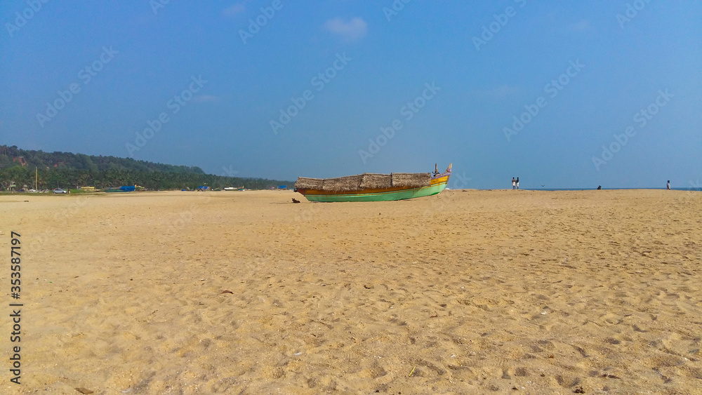 Landscape image of sandy Azhimala Beach in Trivandrum, Kerala, India with a parked fishing Boat on sand. Landscape image of sandy Azhimala Beach in Trivandrum, Kerala, India with a parked fishing Boat on sand.