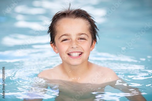 Happy boy smiling and playing in a swimming pool