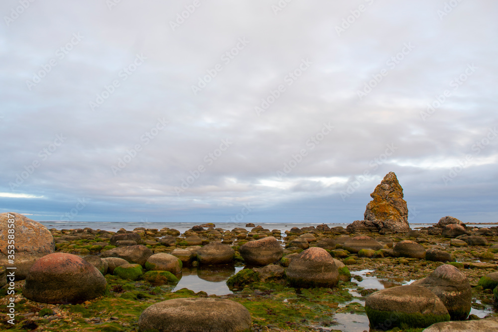 Limestone stack in shallow water during an cloudy sunrise at island of Gotland in Sweden