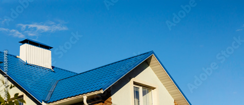 Fotografía A roof of a house or cottage made of blue metal tiles with drains, slopes and ch