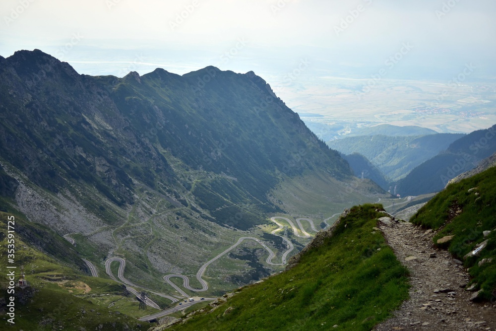 asphalt road crossing rocky mountains in spring season