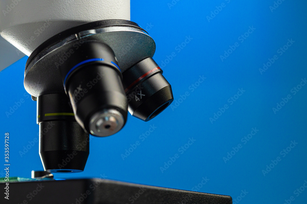 Close up photo of a microscope lenses examining glass sample Close up photo of a microscope lenses examining glass sample