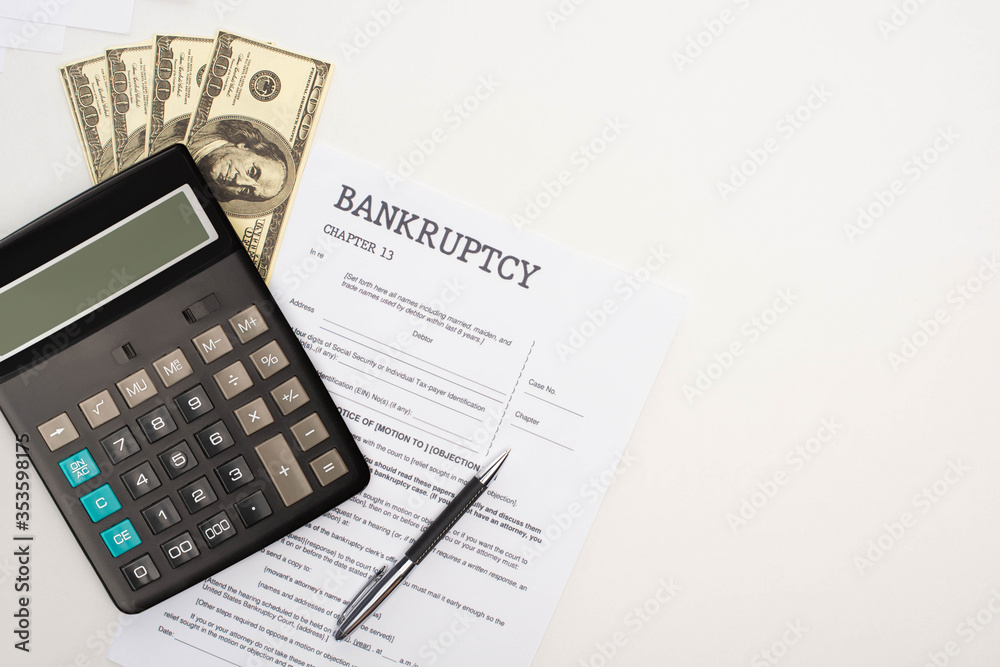 top view of bankruptcy paper with pen, money and calculator on white background top view of bankruptcy paper with pen, money and calculator on white background