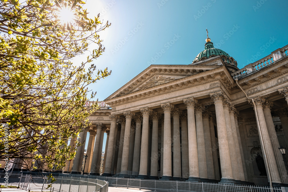 Kazan Cathedral on a Sunny summer day, a beautiful green Bush on the side and the glare of the sun in St. Petersburg