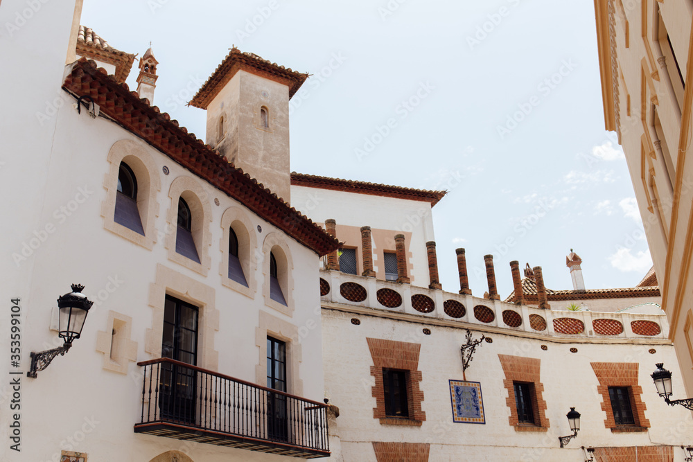 Low angle view of street lanterns on facades of buildings with blue sky at background in Catalonia, Spain