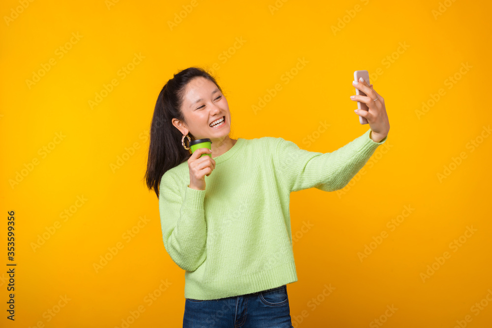 Cheerful young smiling woman is making a selfie while holding her to go cup Cheerful young smiling woman is making a selfie while holding her to go cup
