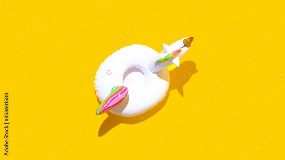 Inflatable unicorn pool toy on yellow background. Minimal summer concept. High quality FullHD footage Inflatable unicorn pool toy on yellow background. Minimal summer concept. High quality FullHD footage