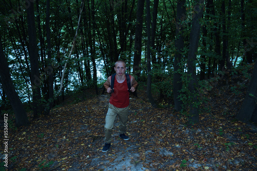 Top view on a young tourist man with a backpack in a dark forest. Outdoor travel © YAROSLOVEPHOTOVIDEO