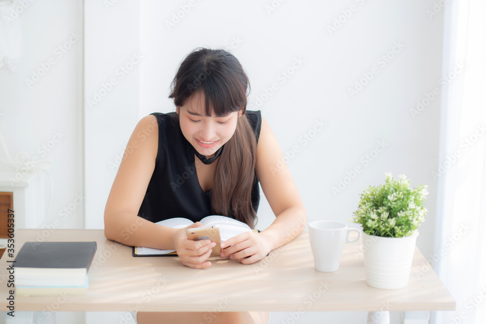 Beautiful young asian woman using touch smart mobile phone chatting message and notebook on desk, asia girl looking social network or check email at table, communication and lifestyle concept. Beautiful young asian woman using touch smart mobile phone chatting message and notebook on desk, asia girl looking social network or check email at table, communication and lifestyle concept.