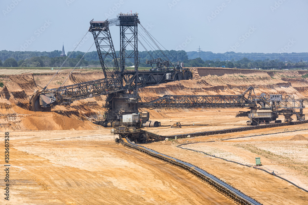 Brown coal open pit landscape with digging excavator in Germany Brown coal open pit landscape with digging excavator in Germany