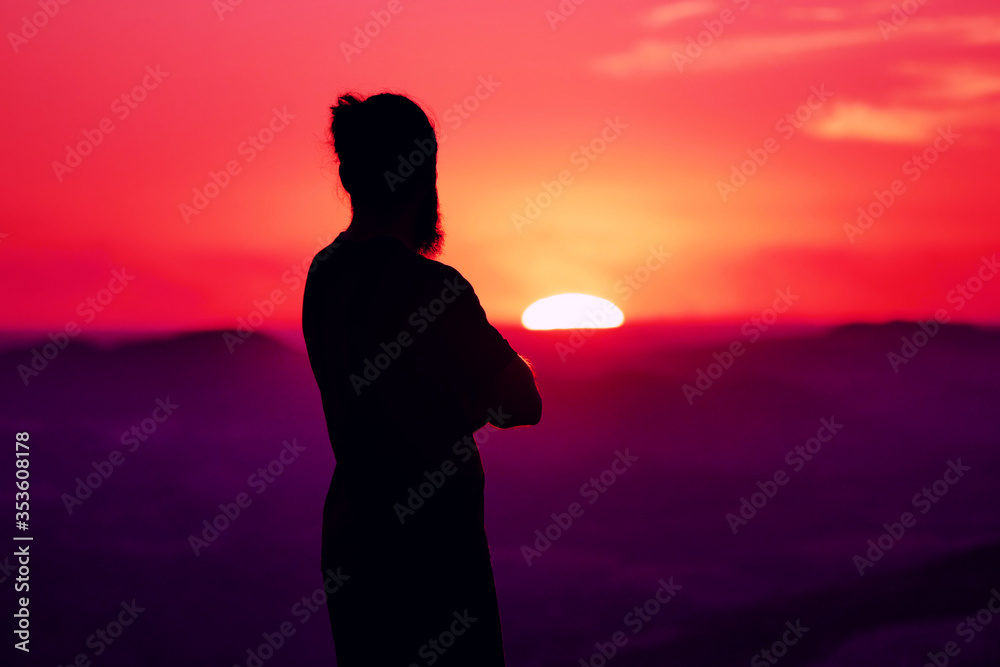 Silhouette of man over sunset