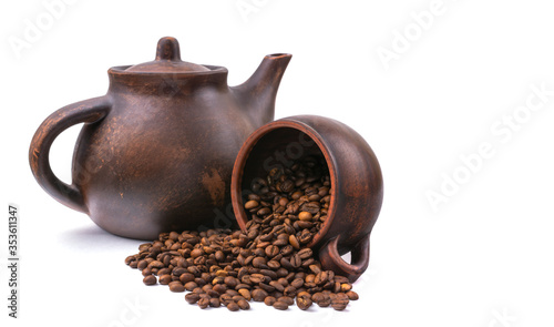 inverted mug with coffee beans on the background of a clay teapot, isolated on white