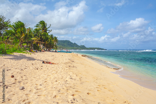 Beautiful beach in the Philippines with blue cloudy sky and palm trees