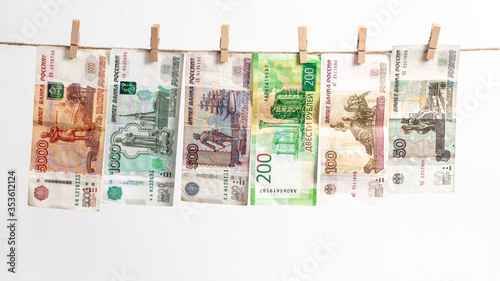Russian rubles hang on a rope on a white