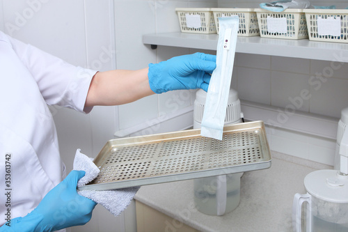 Sterile dental instruments in sealed craft packages. The concept of sterility and hygiene in clinics. An unrecognizable photo without a face. Copy of the space.