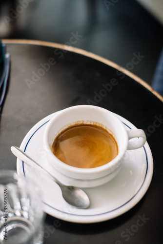 A cup of delicious fresh morning espresso coffee with a beautiful crema on the table, close up view 